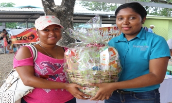 Aldesha Sanchez from Roaring Creek receiving basket of Belizean products, courtesy of Beltraide